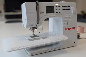 Machine à coudre Bernina B335 sur une table de travail, avec tablette d’extension.